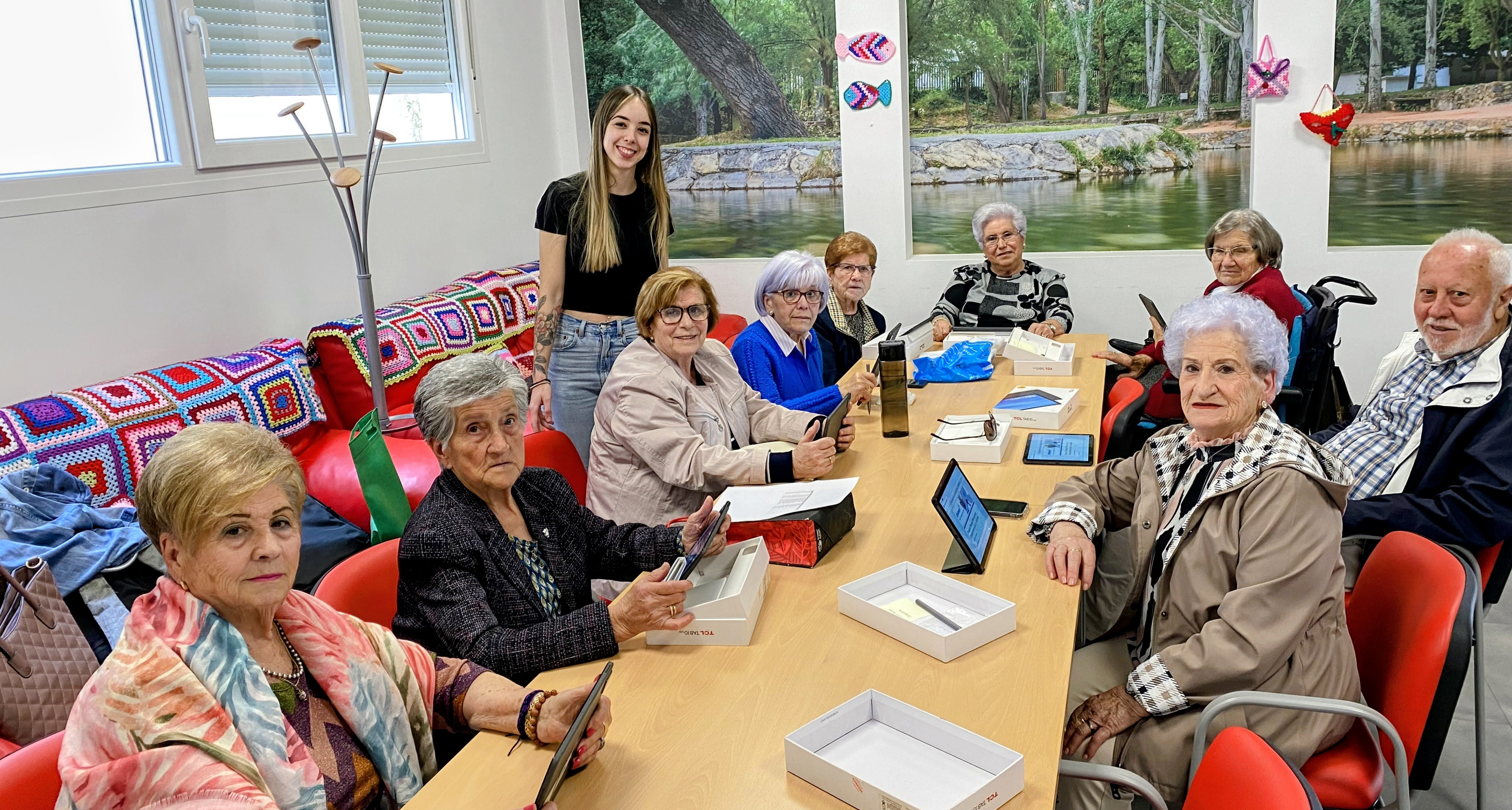 Foto de trabajo donde se ve a personas sentadas alrededor de una mesa alargada