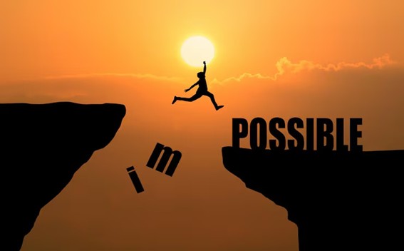 Silueta de una persona saltando entre dos acantilados al atardecer, donde las letras 'i' y 'm' caen del acantilado izquierdo transformando la palabra 'impossible' en 'possible' en el acantilado derecho
