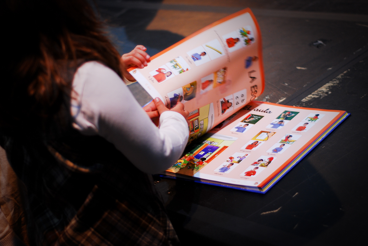 Imagen de una niña manejando un libro con pictogramas 