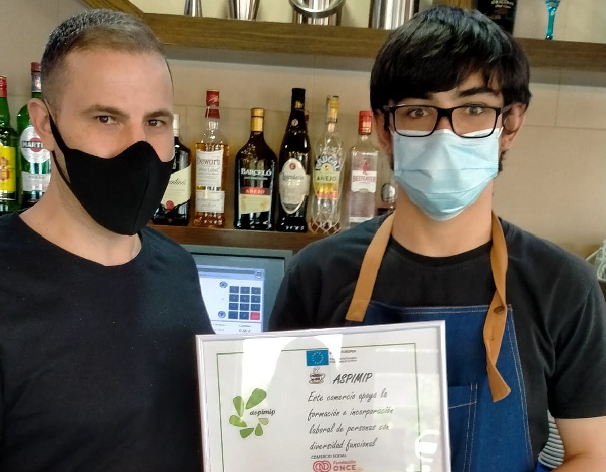 Antonio enseñando su diploma junto a su profesor