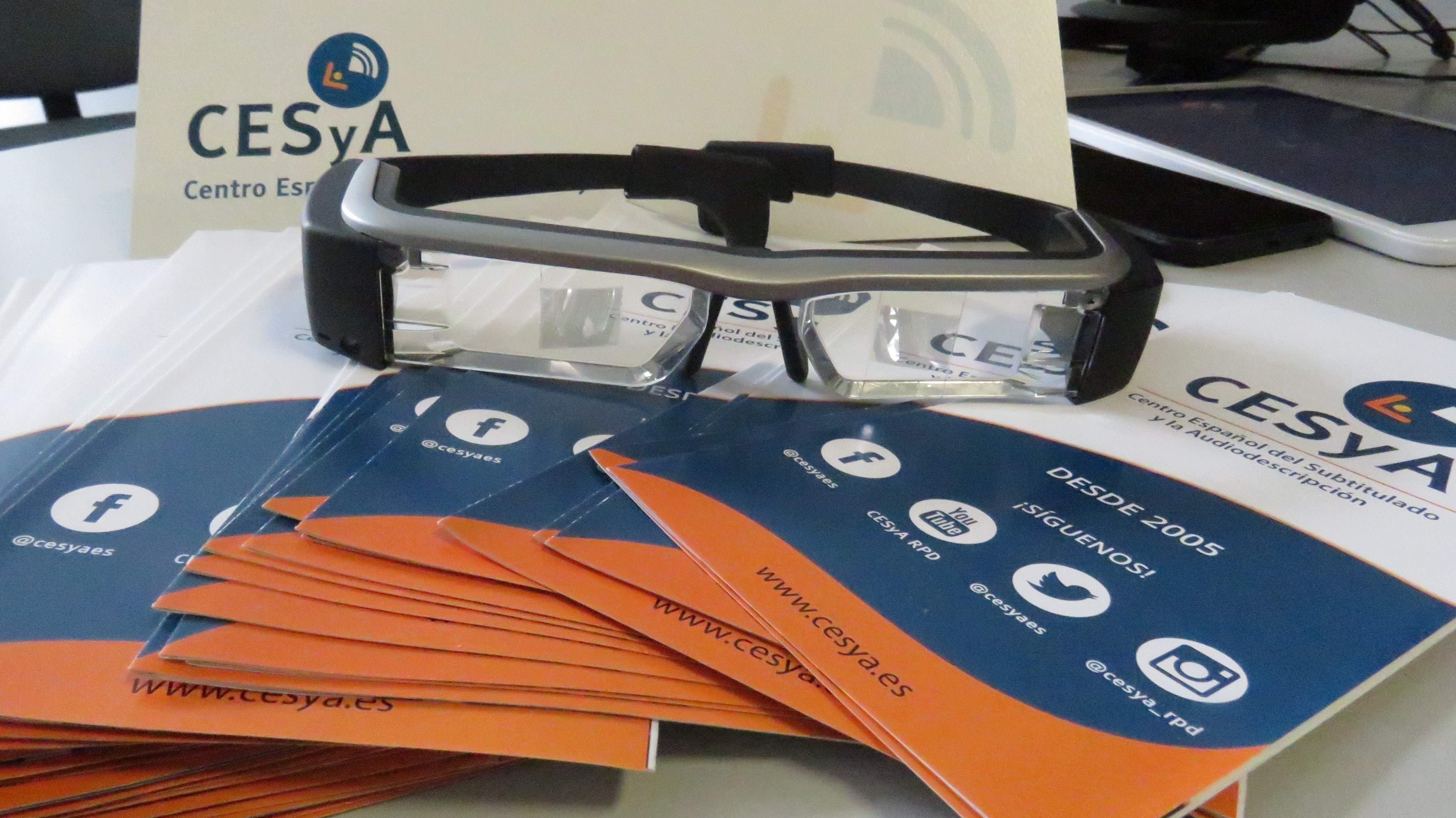 Imagen de unas gafas sobre unos folletos en la que se lee también la palabra CESyA