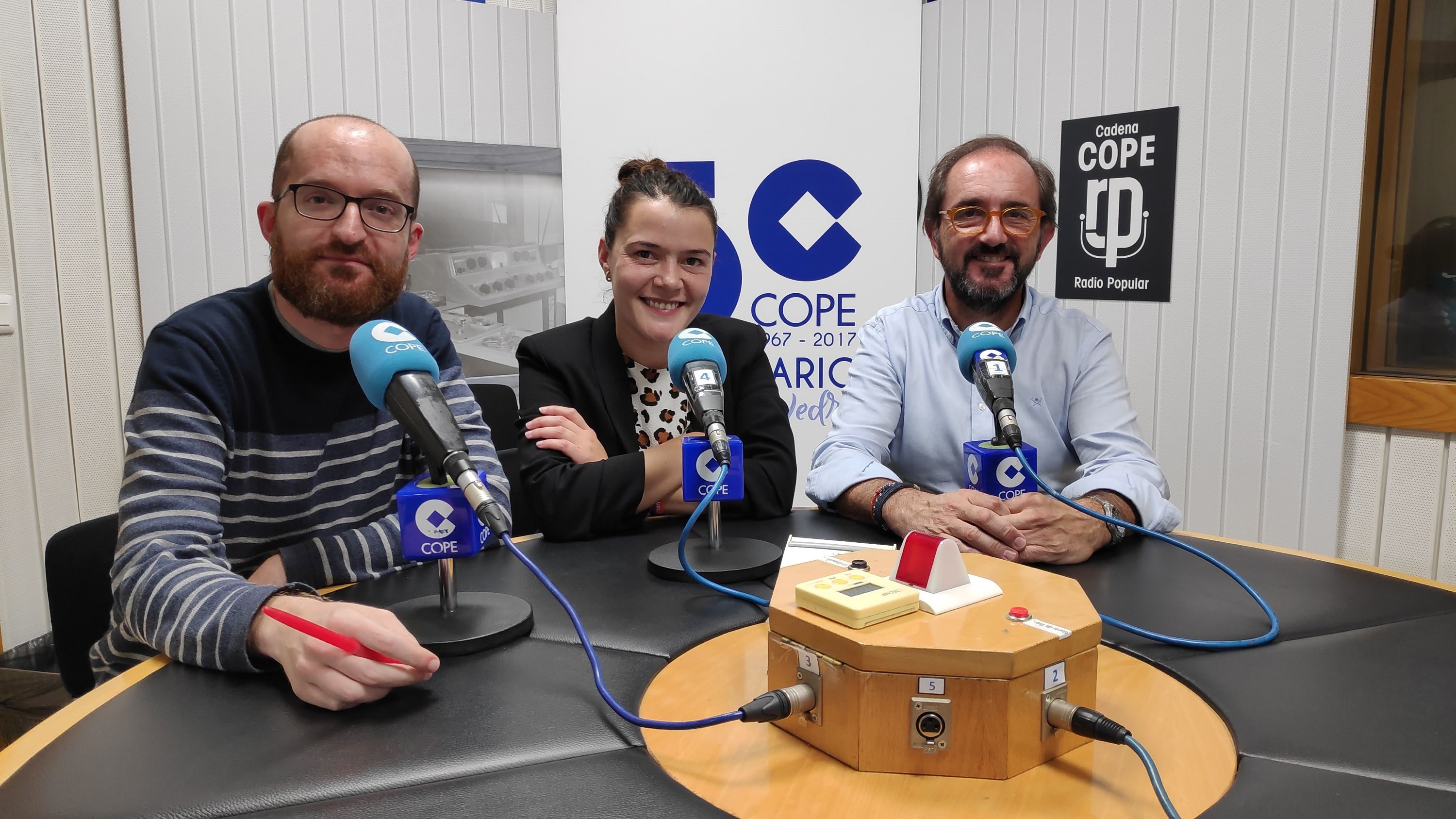Imagen de José Jardón ante el micrófono con dos compañeros 