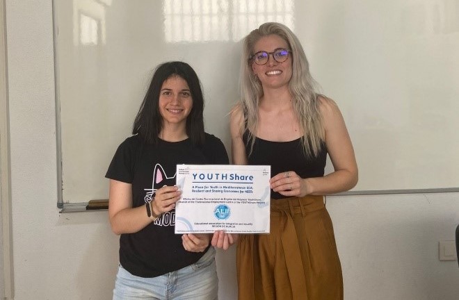 María, junto a una compañera, mostrando un diploma obtenido durante la formación realizada con la beca CRUE-Fundación ONCE