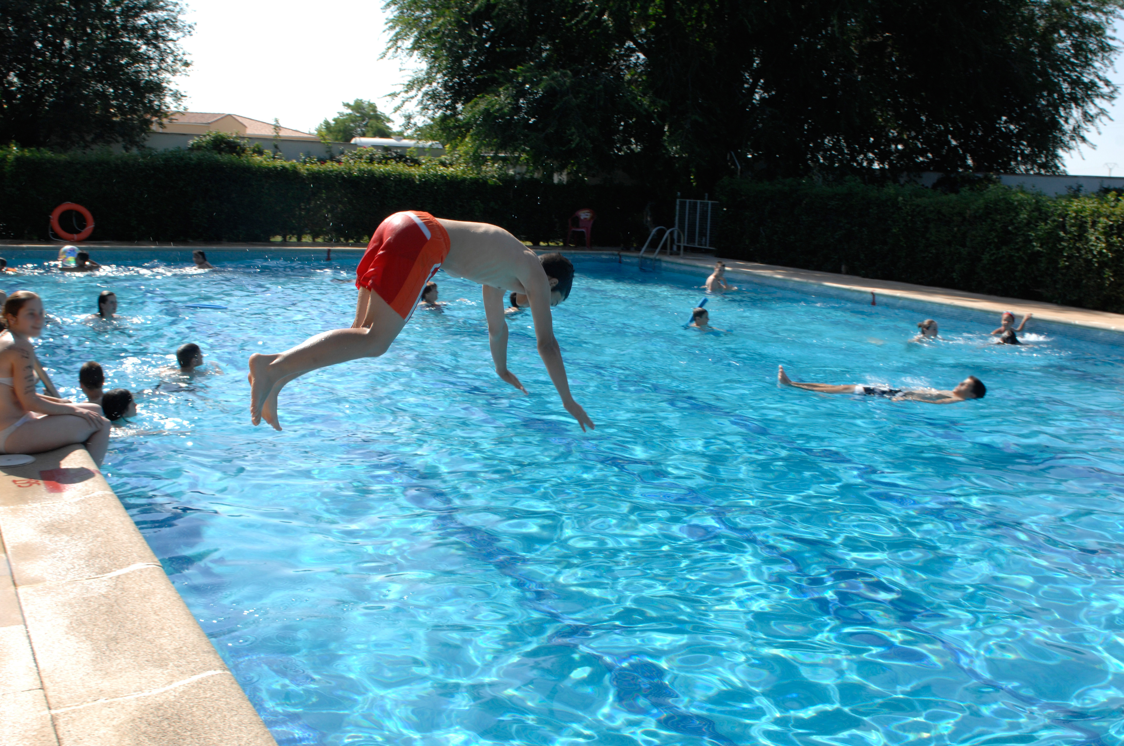 Persona tirándose de cabeza a una piscina