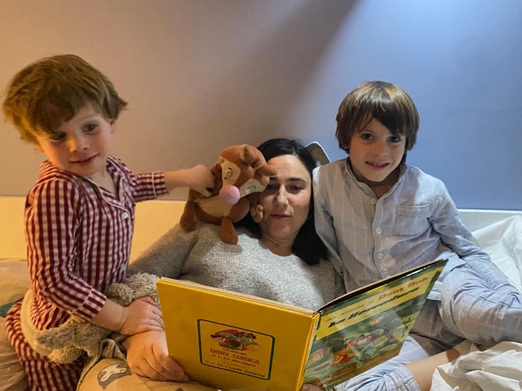 Imagen de Marieta con sus hijos leyendo un cuento