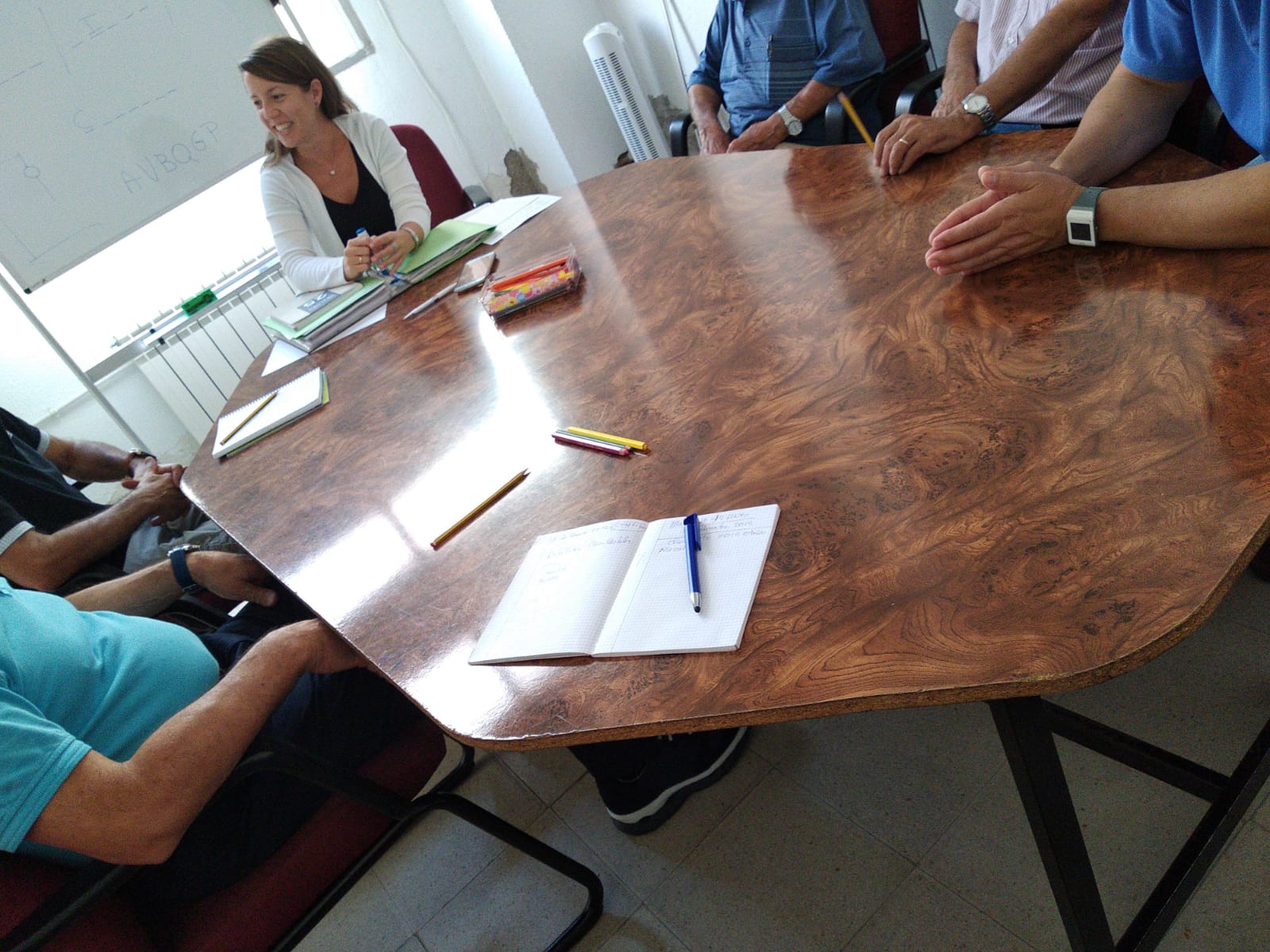 Imagen de uno de los talleres de Cristina en el que aparecen las manos de varias personas alrededor de una mesa redonda