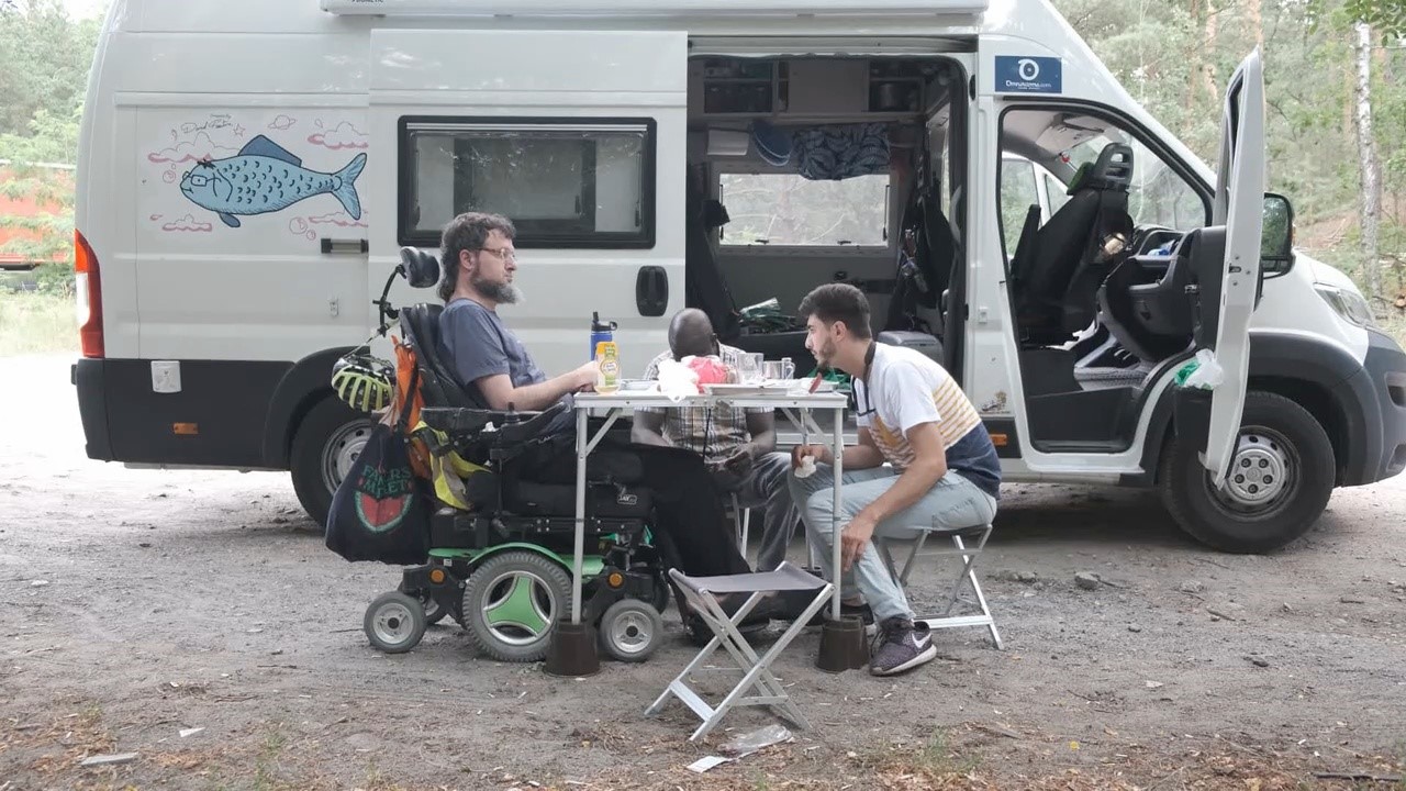 Foto de Daviz Riaño junto a su caravana y a uno de sus compañeros de viaje