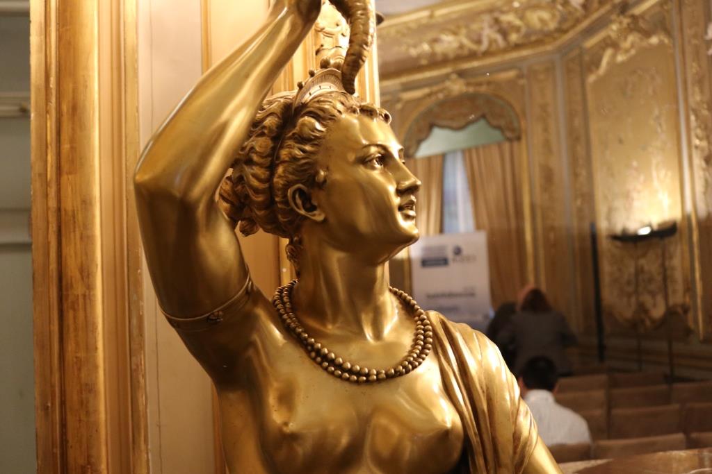 Estatua dorada de una musa en la sala Miguel de Cervantes del Museo de América