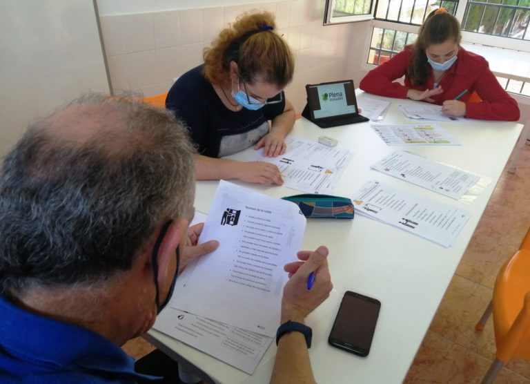 Foto en la que se ve a validadores trabajando con los textos alrededor de una mesa