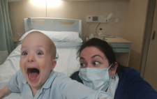 José María, sin pelo y en pijama, al lado de María Teresa, con mascarilla quirúrgica, delante de una cama de hospital  