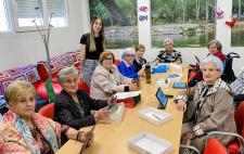 Foto de trabajo donde se ve a personas sentadas alrededor de una mesa alargada