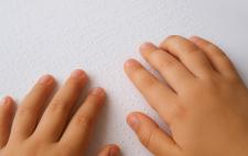 Imagen de unas manos leyendo braille