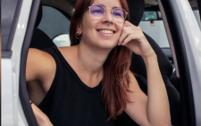 María sentada en la puerta abierta de una furgoneta blanca, con expresión relajada 