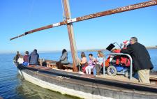 Foto de una barca accesible con personas con y sin discapacidad