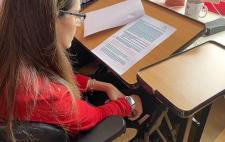 Foto de María estudiando en una mesa con ordenador 