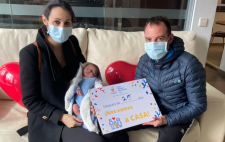 Foto de la familia con un cartel que pone 'Después de 25 días nos vamos a CASA'