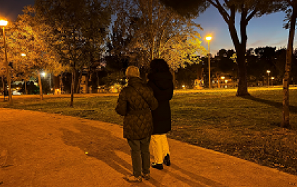 Natalia y Mari Ángeles de espaldas, paseando por un parque en el que predominan los colores ocres 