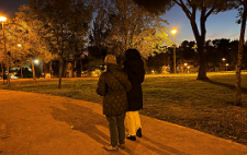Natalia y Mari Ángeles de espaldas, paseando por un parque en el que predominan los colores ocres