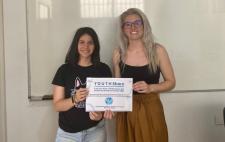 María, junto a una compañera, mostrando un diploma obtenido durante la formación realizada con la beca CRUE-Fundación ONCE 