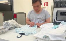 Foto de César poniendo la alarma a una prenda de ropa durante sus prácticas en Carrefour