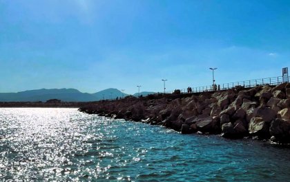 Imagen de un paisaje costero en la que se ve el mar y un rompeolas que se extiende hacia el horizonte