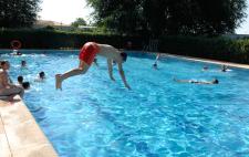 Persona tirándose de cabeza a una piscina