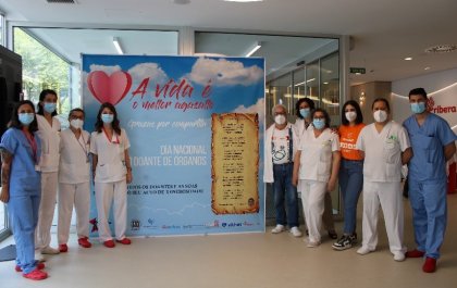 Foto de la campaña de captación de donantes en el hospital Ribera Salud en la que se ve a personal sanitario y no sanitario a ambos lados de un panel informativo