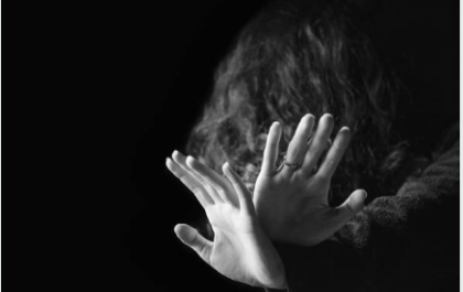 Foto de una mujer con las manos delante de la cara en señal de defensa ante una agresión