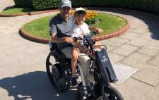 Enrique en silla de ruedas con su hijo sentado encima