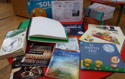 Foto de varios libros entre los que se ven algunos infantiles y uno en braille