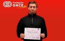 Foto de Nicanor Zalba mostrando el diploma de su beca