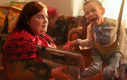 Foto en la que se ve a Bohdan sonreír junto a su madre, Ivanka, mientras usa el rastreador ocular