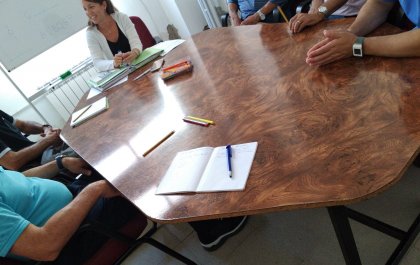 Imagen de uno de los talleres de Cristina en el que aparecen las manos de varias personas alrededor de una mesa redonda