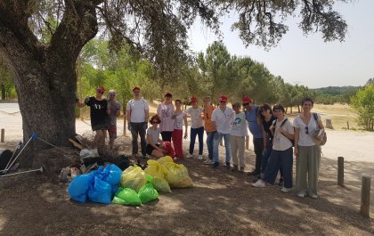 Foto en la que se ve al grupo de participantes con bolsas llenas de basura