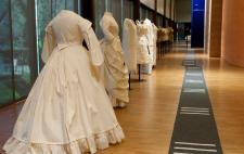 El área didáctica y multisensorial del Museo del Traje Foto de varios trajes de época puestos en fila, obra de Francisco Javier Maza