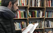 Imagen de Tomás ante un texto en una biblioteca