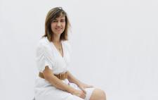 Imagen de María sentada, vestida de blanco y con las manos en las rodillas