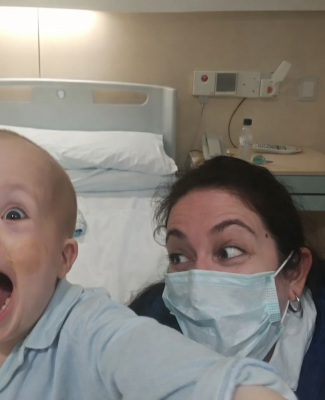 José María, sin pelo y en pijama, al lado de María Teresa, con mascarilla quirúrgica, delante de una cama de hospital  