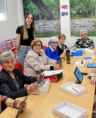 Foto de trabajo donde se ve a personas sentadas alrededor de una mesa alargada