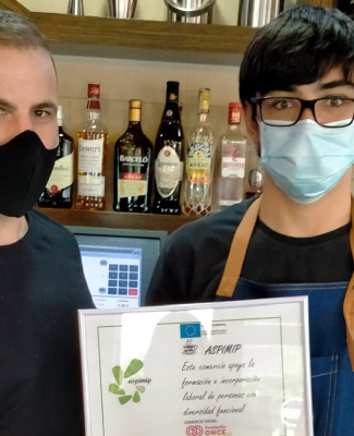 Antonio enseñando su diploma junto a su profesor
