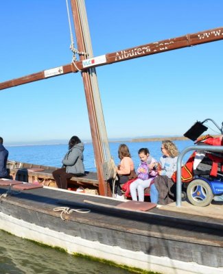 Foto de una barca accesible con personas con y sin discapacidad