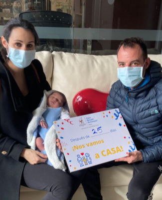 Foto de la familia con un cartel que pone 'Después de 25 días nos vamos a CASA'
