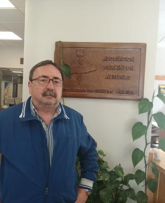 Chema, delante de una placa de la Asociación Parkinson Asturias