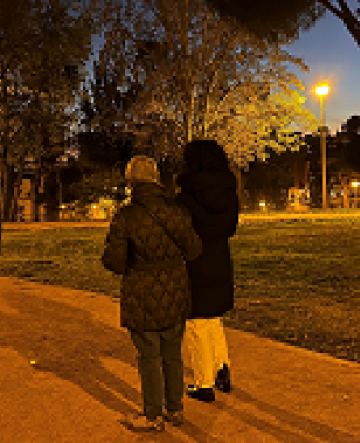 Natalia y Mari Ángeles de espaldas, paseando por un parque en el que predominan los colores ocres 
