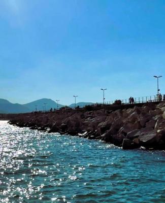 Imagen de un paisaje costero en la que se ve el mar y un rompeolas que se extiende hacia el horizonte