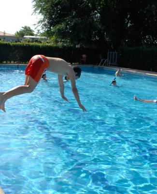 Persona tirándose de cabeza a una piscina