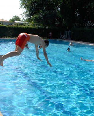 Persona tirándose de cabeza a una piscina