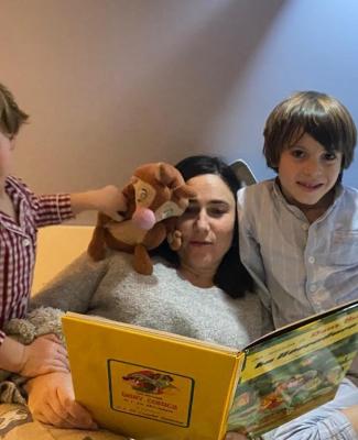 Imagen de Marieta con sus hijos leyendo un cuento