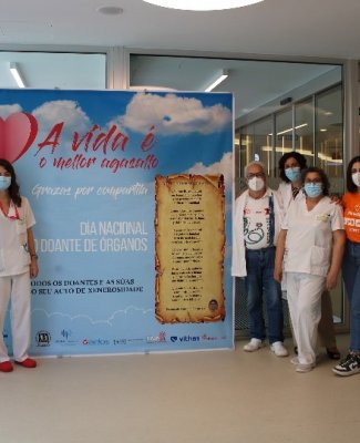 Foto de la campaña de captación de donantes en el hospital Ribera Salud en la que se ve a personal sanitario y no sanitario a ambos lados de un panel informativo