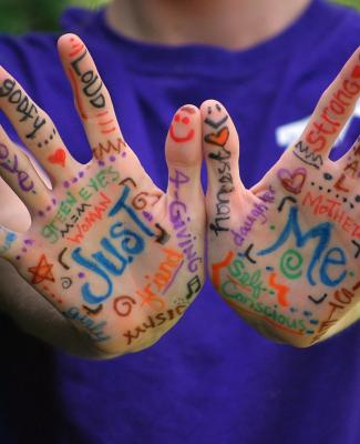 Imagen de dos manos pintadas en las que se lee "Just me"